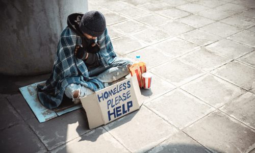 One man, young homeless sitting on the street and begging.